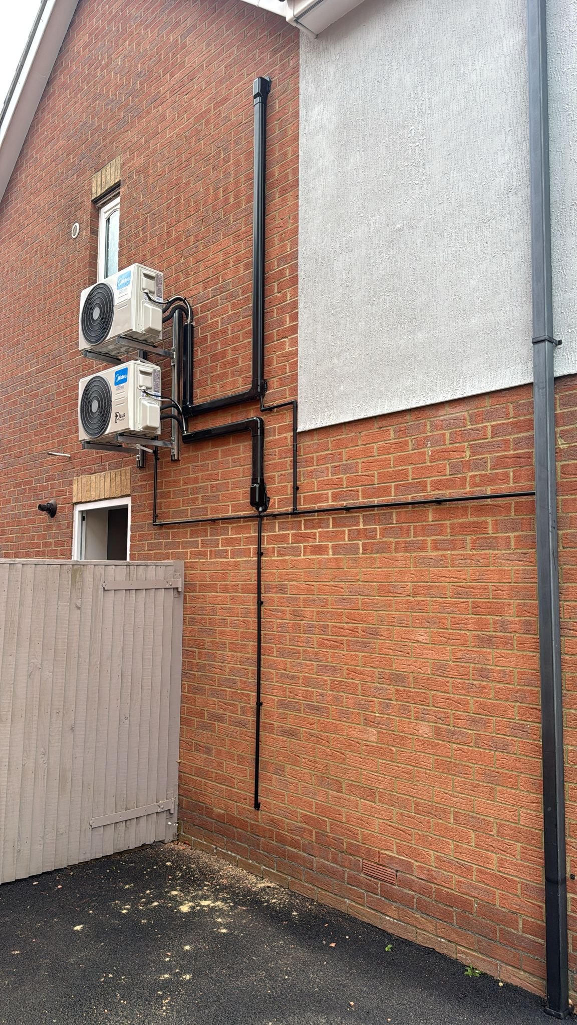 Residential outdoor unit installed at side of house by PDQ Air Conditioning
